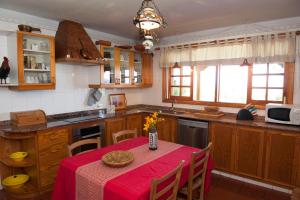 拉奥罗塔瓦Finca Los Pajares的厨房配有一张带红色桌布的桌子