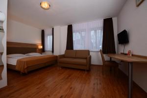 斯图加特林德斯图加特酒店的一间卧室配有一张床、一张沙发和一张书桌
