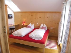 WackersbergLandgasthof Fischbach的卧室配有红色的床和白色枕头