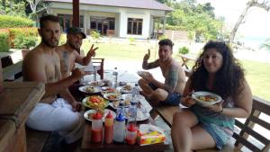 沙璜全景塞拉库住宿加早餐旅馆的一群坐在桌子旁吃食物的人
