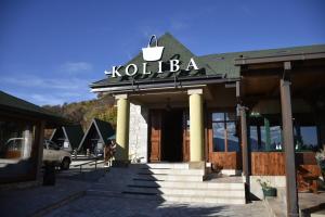 尼克希奇Aparthotel Koliba的上面有标志的建筑