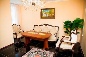 博罗沃耶Hotel Nurlytau的客厅配有桌子和两把椅子