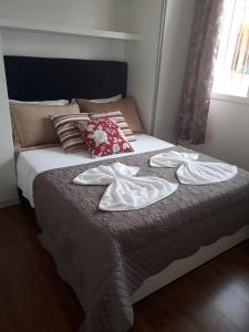 格拉玛多Glamour Gramado Residence的床上有两条毛巾