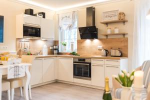 青斯特Villa Strandblick 9的厨房配有白色橱柜和桌子