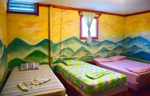莫约加尔帕Hospedaje Central的配有山壁画的客房内的两张床