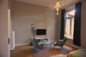 克雷费尔德City-Apartment Reger Privatparkplatz的客厅配有桌椅和电视