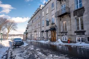 魁北克市苏尔乐凯普庄园酒店的停在大楼旁的一条雪覆盖的街道上
