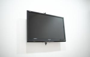 丰盛港MG酒店的挂在白色墙壁上的平面电视