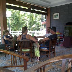 巴图卡拉亚马逊简易别墅&小屋假日公园的一群人坐在椅子上,带着婴儿