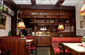 吉赫敦拉特思科勒格尔登酒店的餐厅设有酒吧和桌椅