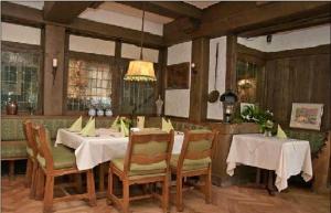 吉赫敦拉特思科勒格尔登酒店的一间配备有白色桌椅的用餐室