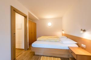 西兰德罗Haus Gufler的一间卧室配有带白色床单和枕头的床。