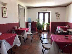 维泰博安迪卡萨斯特农庄酒店的餐厅设有红色和白色的桌椅