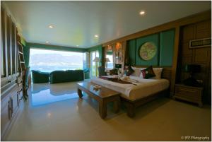 芭东海滩丽格塔克别墅的一间卧室设有一张床和一间客厅。