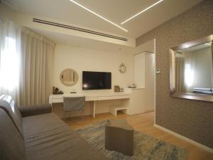 内坦亚马格亚内坦亚酒店的客厅配有沙发和书桌及电视
