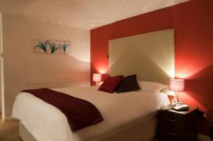 翰索哈维里酒店的卧室配有一张白色大床和红色的墙壁