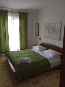 波尔托罗Apartment Vrenjak的一间卧室配有一张带绿色窗帘的床和窗户。