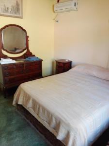 圣奥古斯汀镇Parador La Rosita的一间卧室配有一张床、梳妆台和镜子