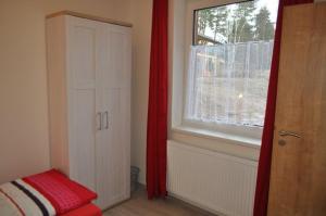 伏尔塔瓦河畔利普诺Moderni Domek Lipno的卧室设有窗户和红色窗帘