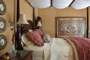 滨湖尼亚加拉苹果树历史住宿加早餐酒店的卧室配有一张床,墙上挂有绘画作品