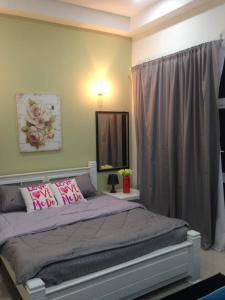 哥打巴鲁Julia's Cottage的卧室配有一张带粉红色枕头的大床