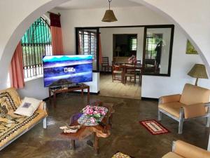 迪亚尼海滩Tradewinds Lodge的一间客厅,客厅内配有大屏幕电视