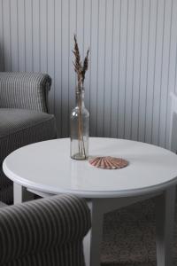HvidbjergTambohus Kro & Badehotel的上面有花瓶的白色桌子