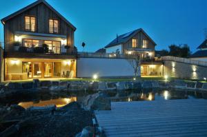 BettelChalets Petry Spa & Relax的夜晚在房子前面有一个池塘