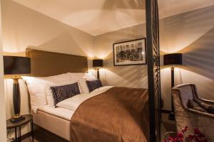 奥斯陆萨迦奥斯陆公寓的一间卧室配有一张床、两盏灯和一把椅子