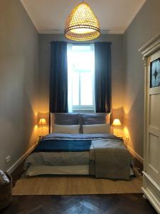 慕尼黑卡斯尔卢德维格乌德弗尔弗瑞恩沃昂公寓的一间卧室配有一张带窗户和吊灯的床。