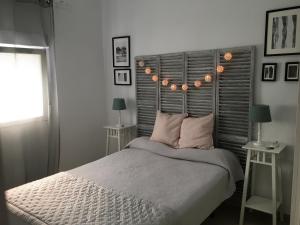 塞维利亚Apartamento Los Naranjos de Santa Justa的一间卧室配有一张床和两张带台灯的桌子。