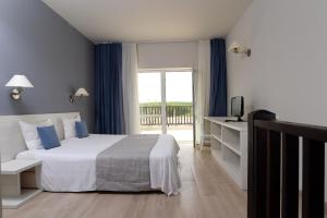 辛尼莫雷特贝拉维斯塔海滩俱乐部全包酒店的酒店客房设有一张床和一个阳台。