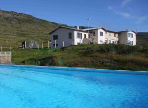 侯尔马维克Hótel Laugarhóll with natural hot spring的房子前面的蓝色游泳池