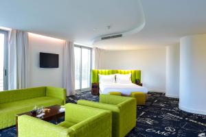 里斯本Hotel da Estrela - by Unlock Hotels的酒店客房,配有一张床和两张绿色椅子
