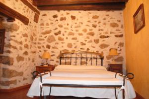 米哈雷斯卡萨多纳里吉亚酒店的卧室配有一张石墙床