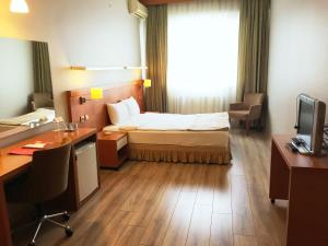 瑟奇科伊柴可兹考商务酒店的酒店客房配有一张床、一张书桌和一台电脑