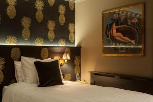 贝尔法斯特House Belfast Hotel的卧室配有一张床,墙上挂有绘画作品
