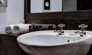 贝尔法斯特House Belfast Hotel的浴室水槽设有2个水龙头和镜子
