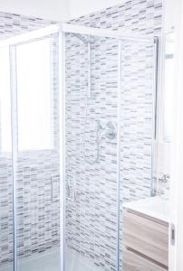 格鲁利亚斯科Gru House的带淋浴和盥洗盆的白色浴室