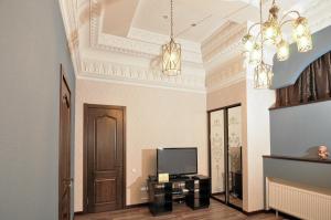 哈尔科夫Мини-Отель "Навруз"的一间带电视和吊灯的客厅