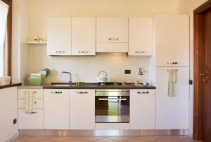 ParellaAppartamento panoramico的厨房配有白色橱柜和水槽