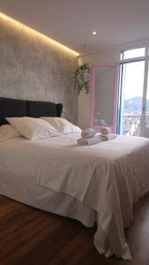 宏达瑞比亚Hotel San Nikolas Sea Views的卧室配有一张大白色床和窗户