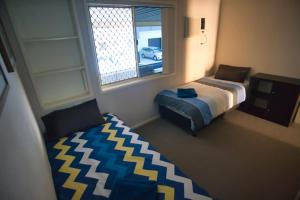 布里斯班Mount Gravatt Guesthouse的一间卧室设有一张床和一个窗口