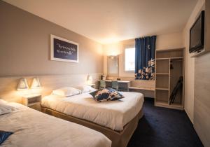 普罗旺斯地区萨隆Ace Hôtel Salon de Provence的酒店客房设有两张床和电视。