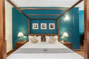 科伦坡Colombo Court Hotel & Spa的一间卧室配有一张带蓝色墙壁的大床