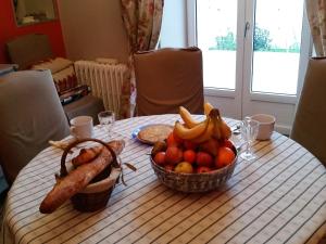 CordemaisGîte Mido的一张桌子,上面放着一碗水果和一篮香肠