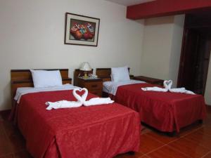 特鲁希略Hotel Plaza Bolognesi 344的两张带毛巾天鹅的床。