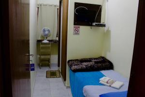 CanoinhasHotel Guarany的小房间设有床和电视