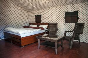 柴尔丛林住宿豪华帐篷的一间小卧室,配有一张床和一把椅子