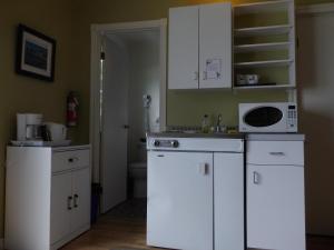 卡穆拉斯卡凯博乐可汽车旅馆 的厨房配有白色橱柜和微波炉